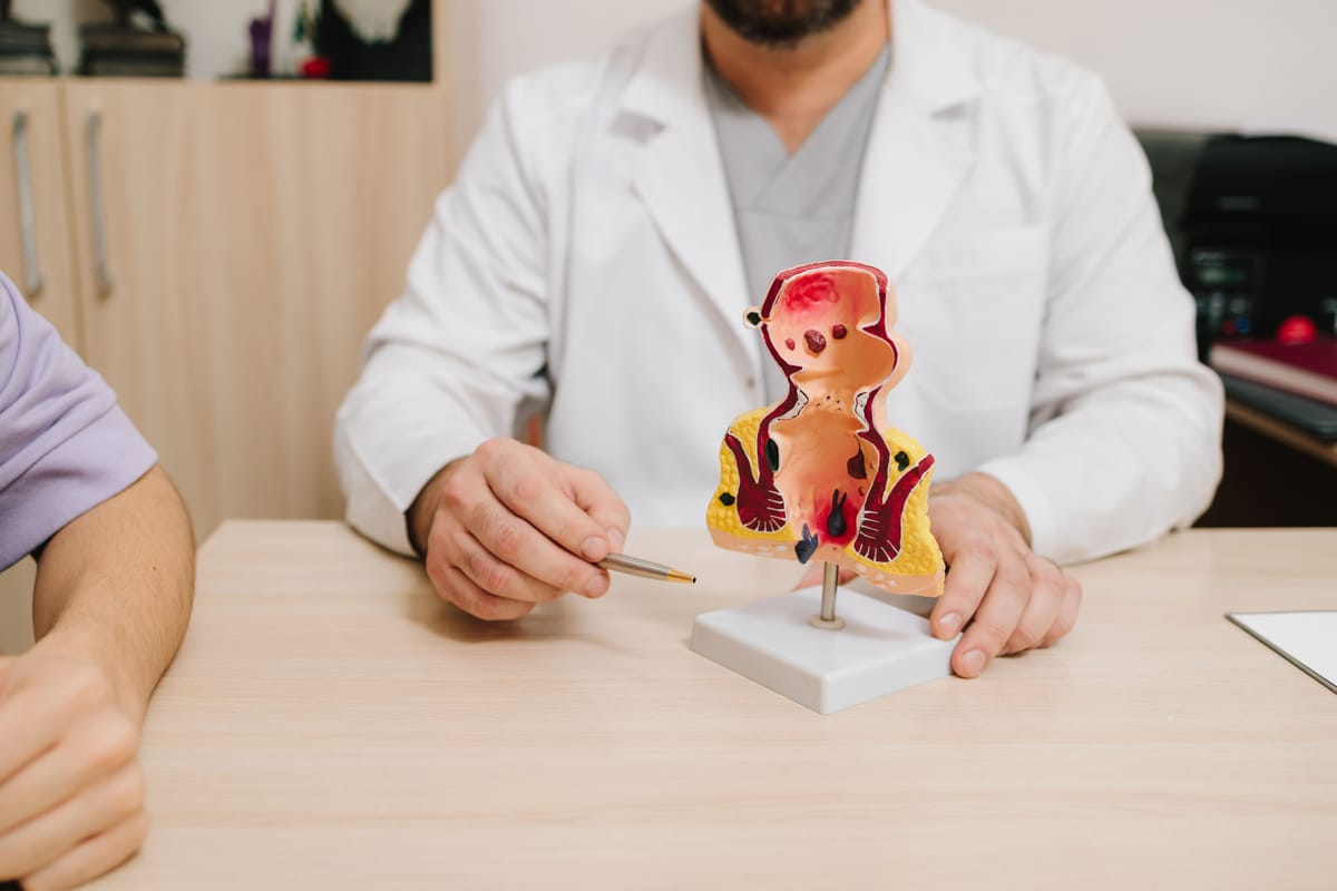 Médico explicando anatomia em consulta de Coloproctologia