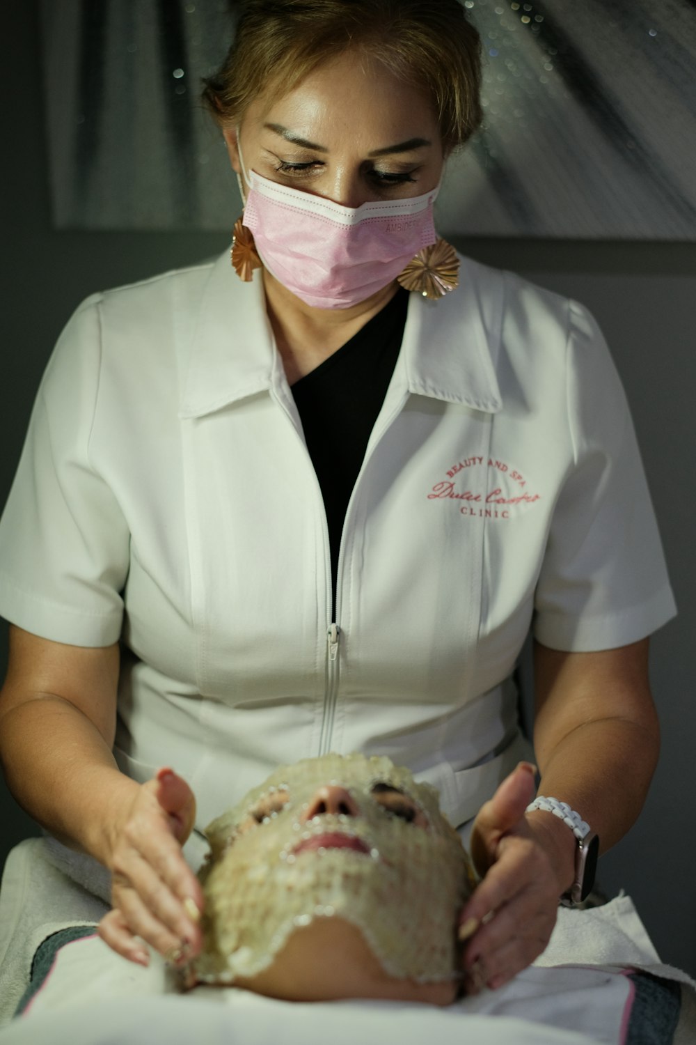 Esteticista aplicando máscara facial em cliente